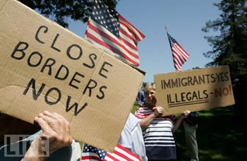 Protesters with signs: "Close borders now" and "Immigrants: yes; illegals: no".