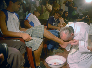 Pope Francis washes and kisses man's feet.