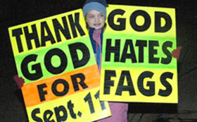 Woman holding posters: "Thank God for Sept. 11" and "God hates fags".