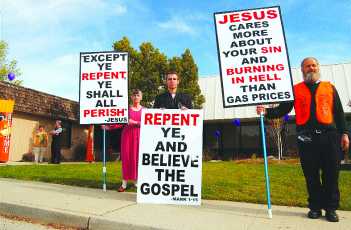 Protesters with "Repent and believe the gospel" signs.