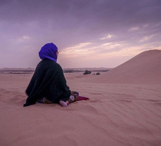Muslim woman prays in the desert.